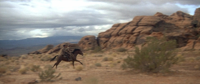 Wide shot frame from Butch Cassidy and the Sundance Kid — sitting, hat, coat