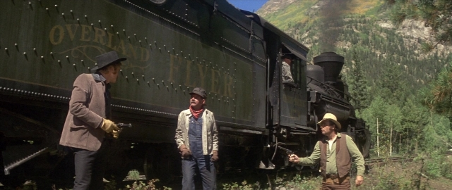 Wide shot frame from Butch Cassidy and the Sundance Kid — standing, gun, train