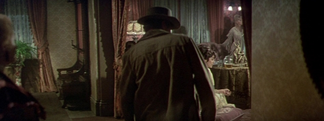 Wide shot frame from Butch Cassidy and the Sundance Kid — sitting, book, standing