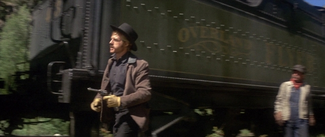 Wide shot frame from Butch Cassidy and the Sundance Kid — standing, hat, car