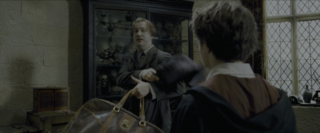 Wide shot frame from Harry Potter and the Prisoner of Azkaban — standing, room, suit