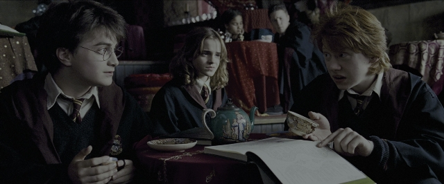 Wide shot frame from Harry Potter and the Prisoner of Azkaban — sitting, book, plate