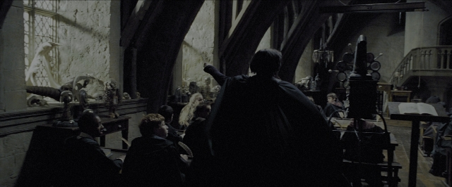 Wide shot frame from Harry Potter and the Prisoner of Azkaban — sitting, book, standing