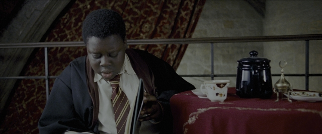 Wide shot frame from Harry Potter and the Prisoner of Azkaban — sitting, book, room