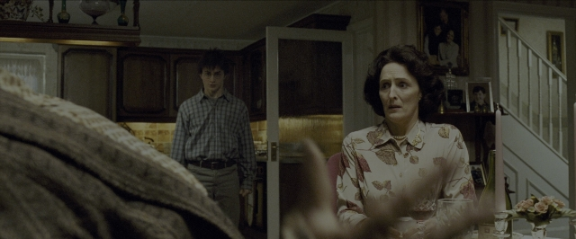 Wide shot frame from Harry Potter and the Prisoner of Azkaban — sitting, standing, table