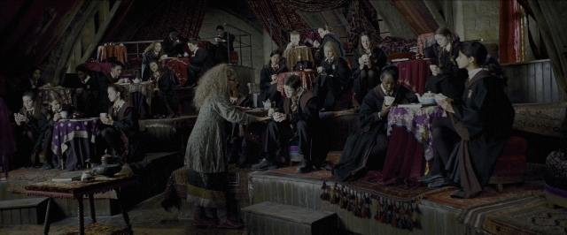 Wide shot frame from Harry Potter and the Prisoner of Azkaban — sitting, book, standing