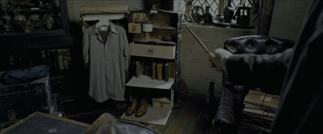 Wide shot frame from Harry Potter and the Prisoner of Azkaban — room, coat, hand