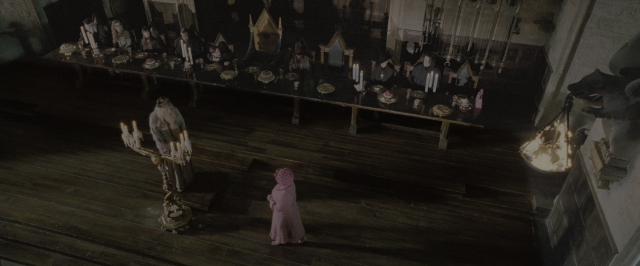 Wide shot frame from Harry Potter and the Order of the Phoenix — standing, room, table