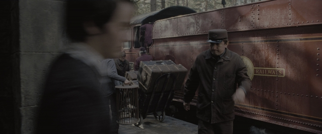Wide shot frame from Harry Potter and the Order of the Phoenix — standing, hat, car