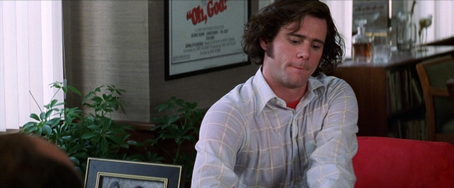 Wide shot frame from Man on the Moon — sitting, room, shirt