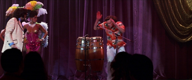 Wide shot frame from Man on the Moon — standing, hand, suit