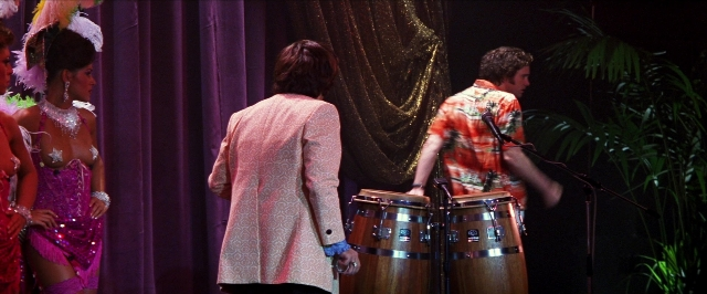 Medium shot frame from Man on the Moon — standing, shirt, drum