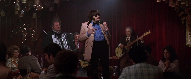 Wide shot frame from Man on the Moon — sitting, standing, hand