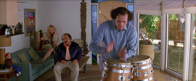 Wide shot frame from Man on the Moon — sitting, standing, house