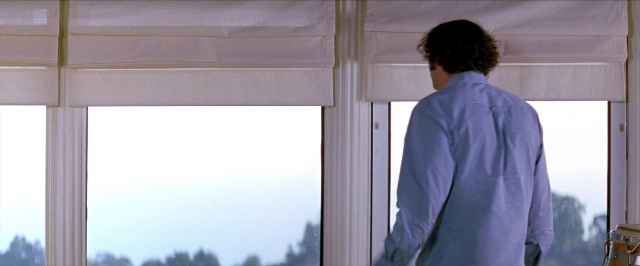 Frame from Man on the Moon — standing, shirt, curtain