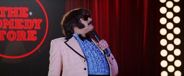 Wide shot frame from Man on the Moon — standing, hand, shirt