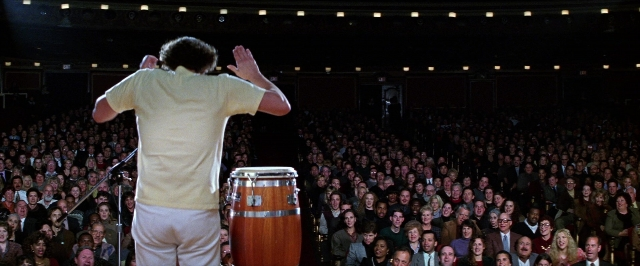 Wide shot frame from Man on the Moon — standing, shirt, drum