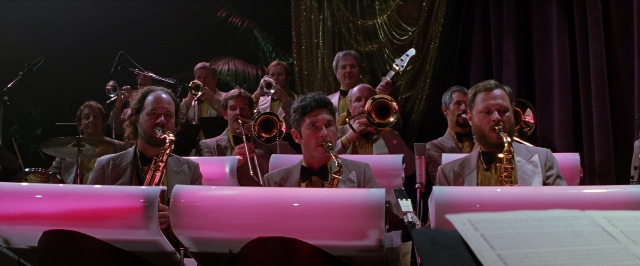 Wide shot frame from Man on the Moon — sitting, saxophone, person