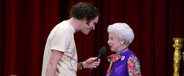 Wide shot frame from Man on the Moon — standing, dialogue, microphone