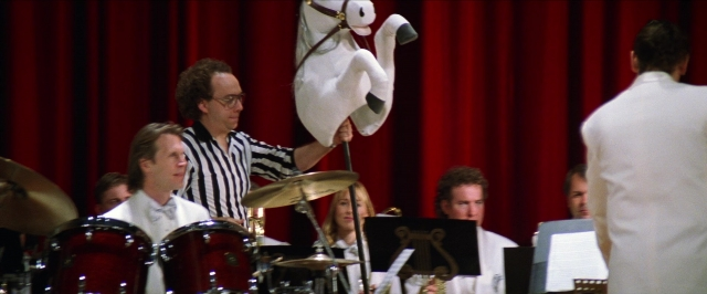 Wide shot frame from Man on the Moon — standing, hat, suit