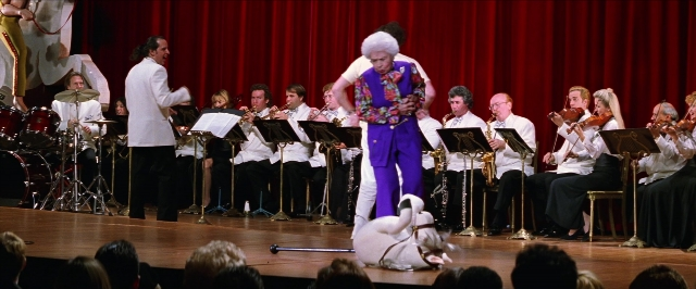 Wide shot frame from Man on the Moon — sitting, standing, suit