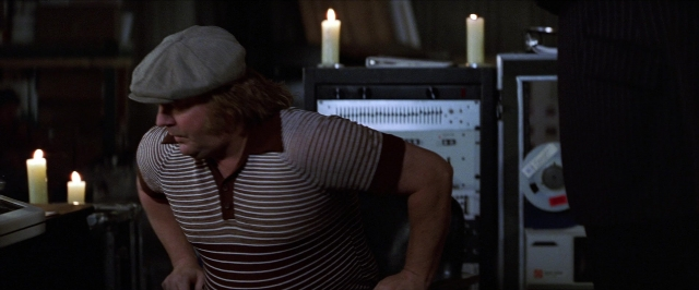 Wide shot frame from Man on the Moon — sitting, room, shirt