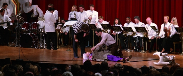 Wide shot frame from Man on the Moon — sitting, standing, shirt