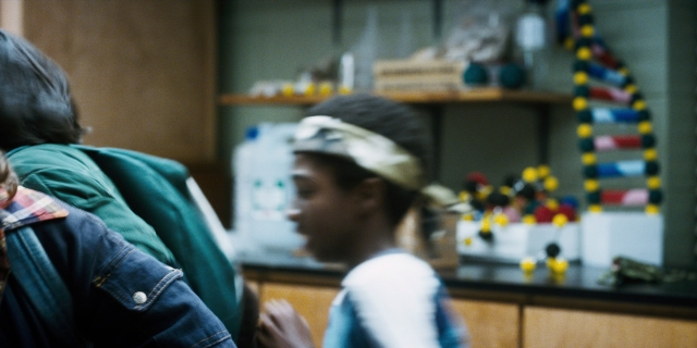 Wide shot frame from Stranger Things — standing, dialogue, hat