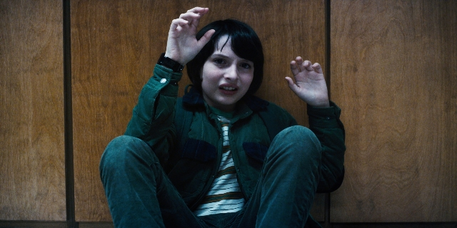 Wide shot frame from Stranger Things — sitting, shirt, face