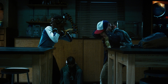 Wide shot frame from Stranger Things — sitting, standing, room
