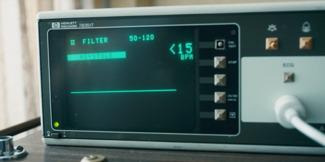 Wide shot frame from Stranger Things — sitting, window, digital clock