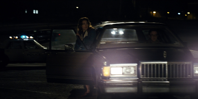 Wide shot frame from Stranger Things — standing, door, car
