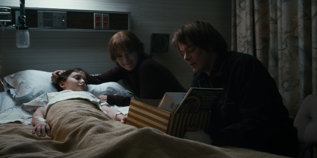 Wide shot frame from Stranger Things — book, bed, face