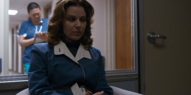 Wide shot frame from Stranger Things — sitting, room, phone