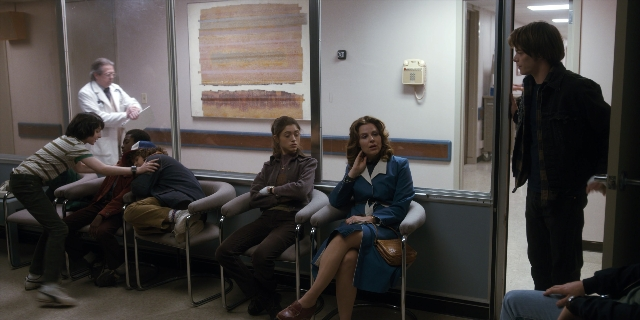 Wide shot frame from Stranger Things — sitting, standing, room