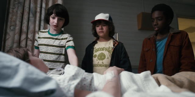 Wide shot frame from Stranger Things — standing, room, bed