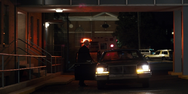 Wide shot frame from Stranger Things — standing, door, street