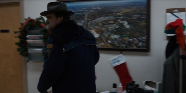 Wide shot frame from Stranger Things — standing, room, hat