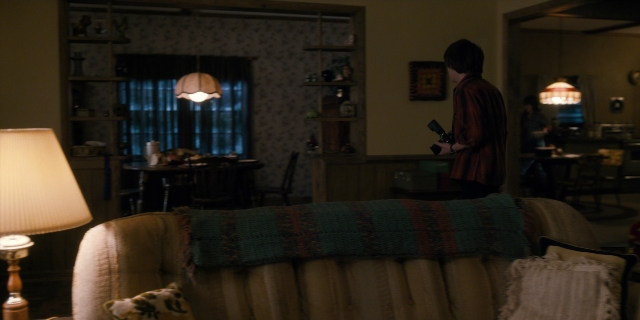 Wide shot frame from Stranger Things — standing, room, table