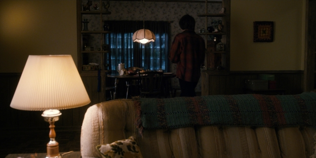 Wide shot frame from Stranger Things — standing, room, table