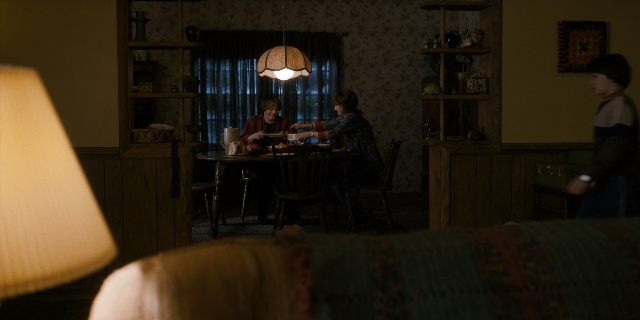 Wide shot frame from Stranger Things — sitting, standing, plate