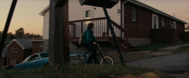 Wide shot frame from Super 8 — street, car, house