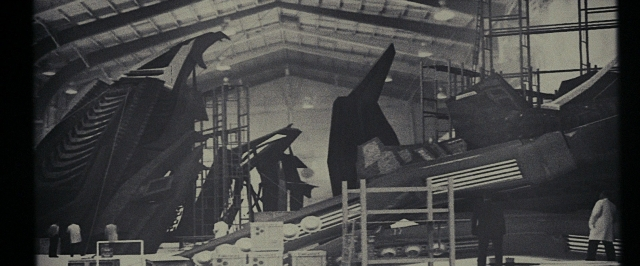 Wide shot frame from Super 8 — standing, room, bird