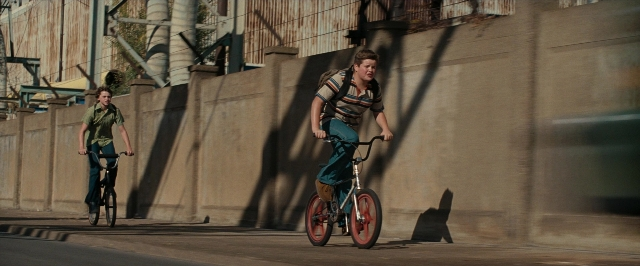 Wide shot frame from Super 8 — street, bicycle, shirt