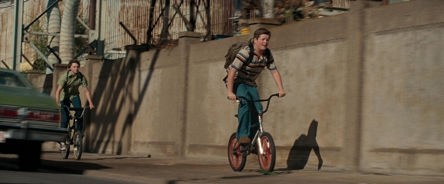 Wide shot frame from Super 8 — street, car, bicycle
