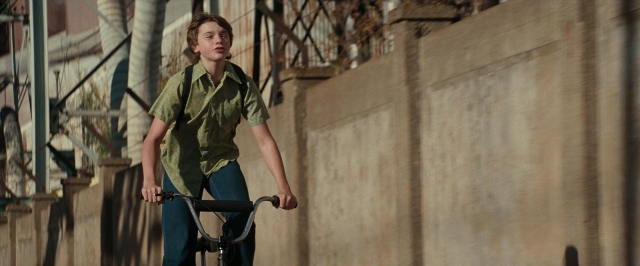 Wide shot frame from Super 8 — street, bicycle, shirt