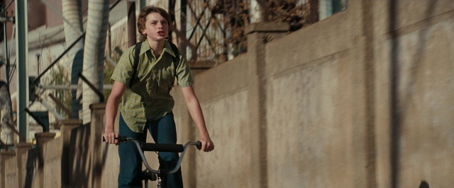Wide shot frame from Super 8 — street, bicycle, shirt