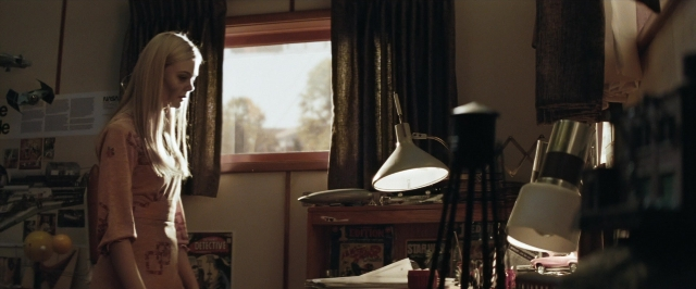 Wide shot frame from Super 8 — standing, room, dress