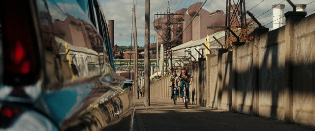 Wide shot frame from Super 8 — street, car, bicycle