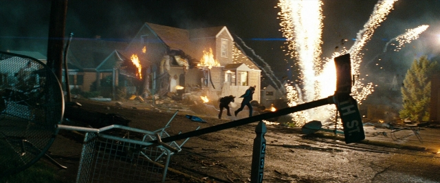 Wide shot frame from Super 8 — street, fire, night